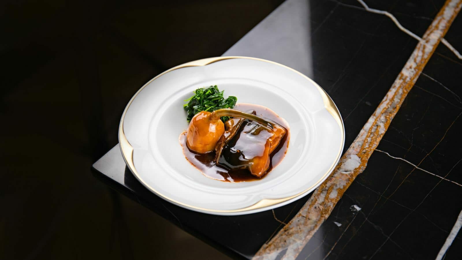 A plated course on dark marble